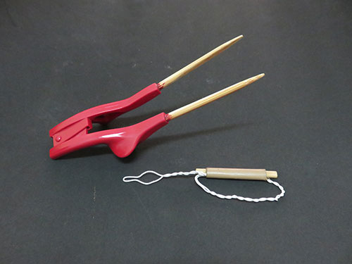 Simple tools like this pair of chopsticks and button hook can make doing tasks easier for disabled people.