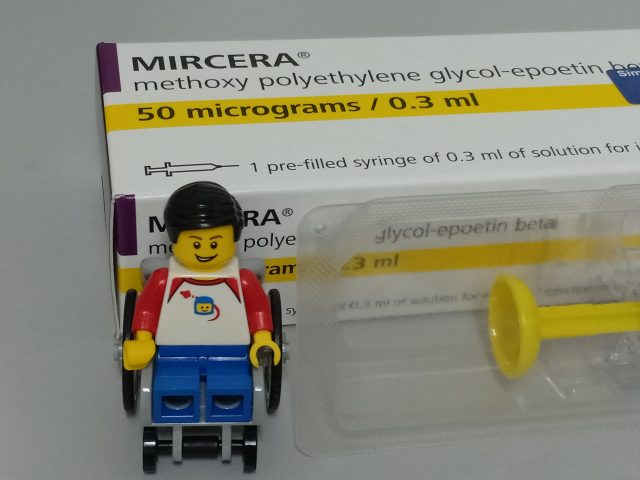 Lego minifigure in wheelchair posing in front of box with the word "Mircera" in bold and "meythoxy polyethylene glycol-epoetin beta" below it.